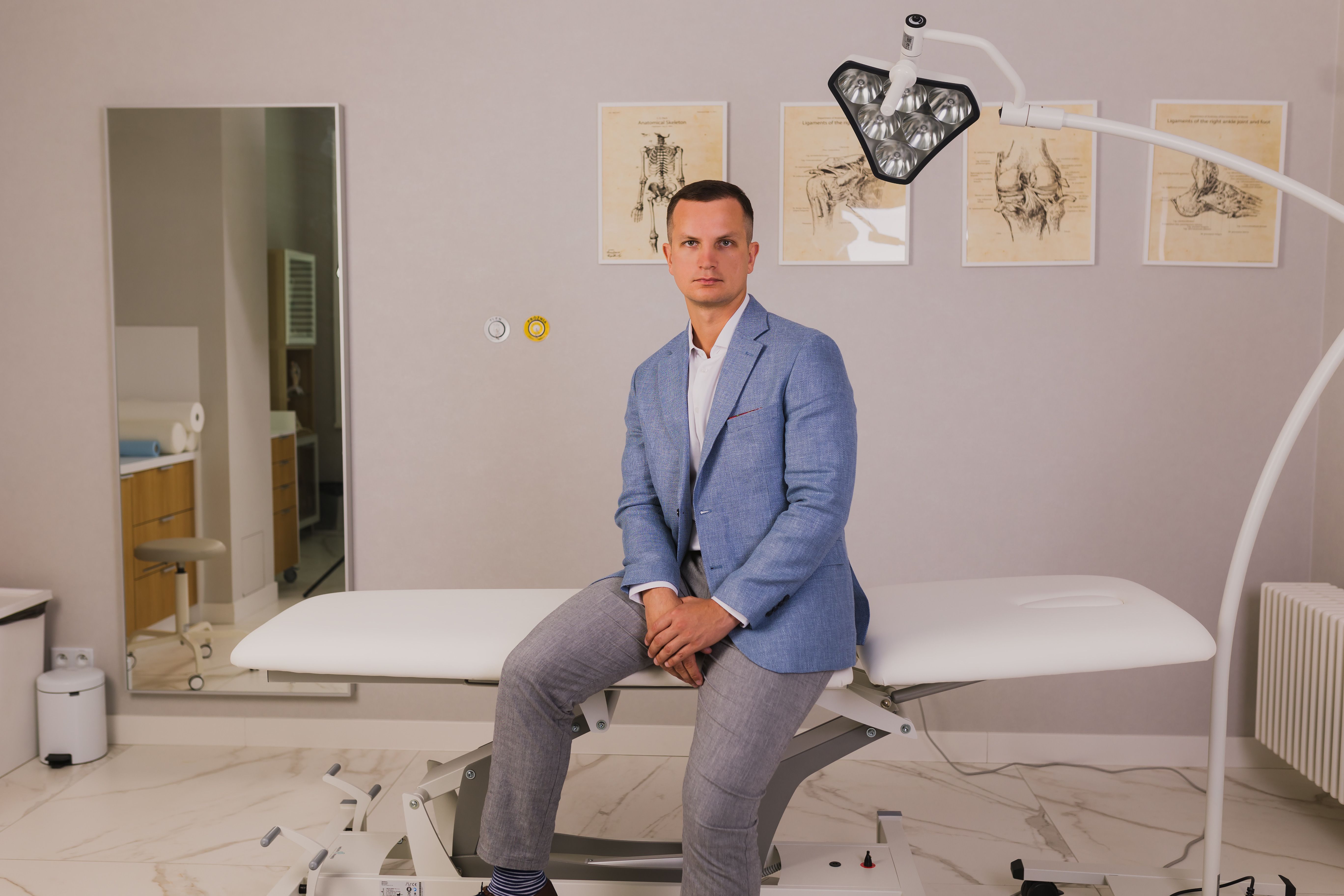 Mateusz Gładysz in an examination room with anatomical posters